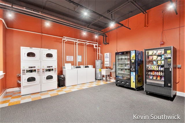 garage featuring electric water heater, washer and clothes dryer, refrigerator, and stacked washer and clothes dryer