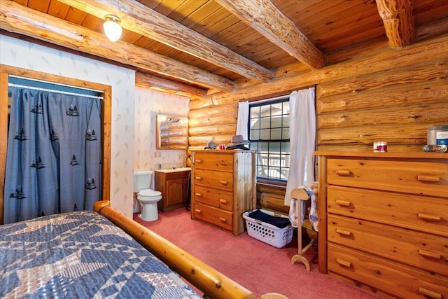 carpeted bedroom with beam ceiling, wood ceiling, rustic walls, and ensuite bath