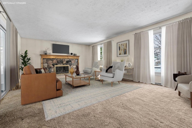 living room with a textured ceiling, light colored carpet, and a fireplace