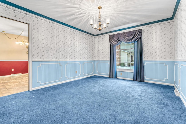 carpeted spare room with ornamental molding and an inviting chandelier