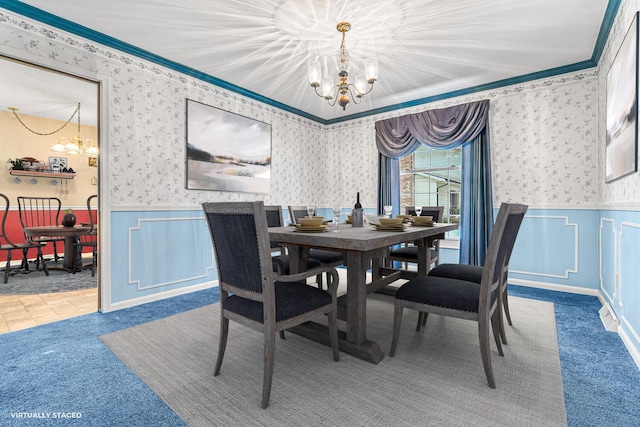 dining space featuring carpet, a chandelier, and crown molding