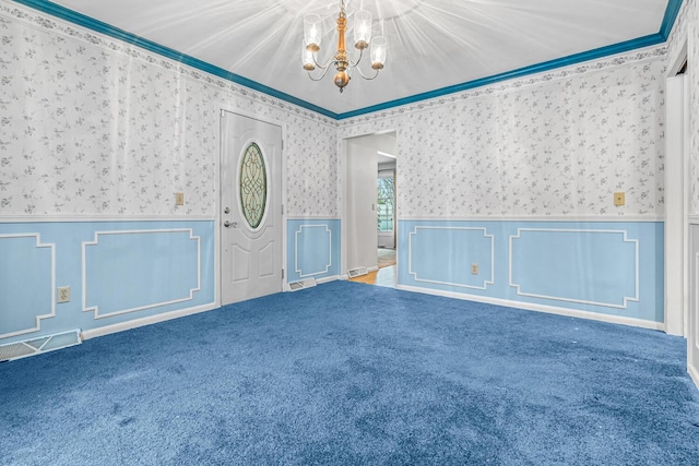 carpeted empty room featuring ornamental molding and a notable chandelier