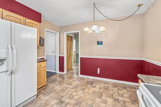 kitchen with pendant lighting, light brown cabinets, stove, white refrigerator with ice dispenser, and a chandelier