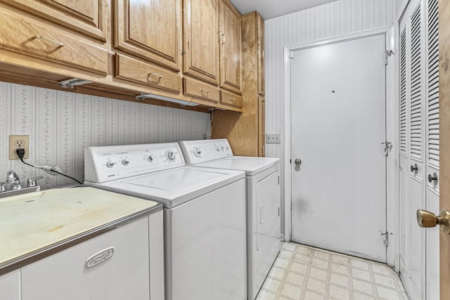 laundry room featuring washer and dryer, sink, and cabinets