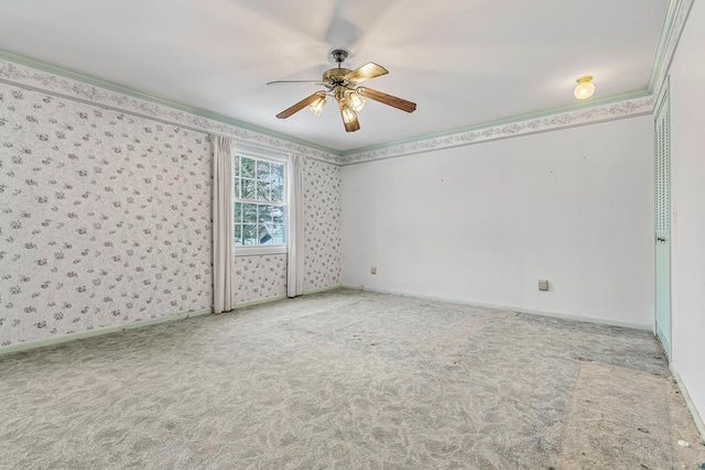 carpeted spare room with ceiling fan and ornamental molding