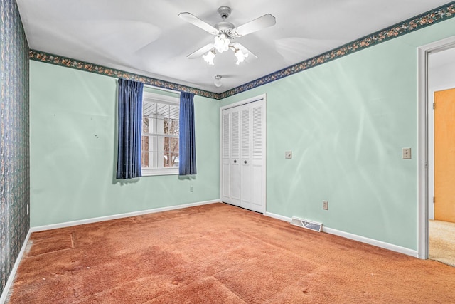 carpeted spare room featuring ceiling fan