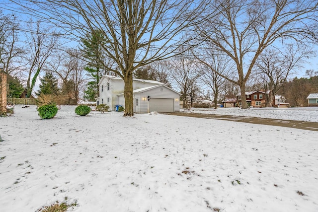 snowy yard featuring a garage