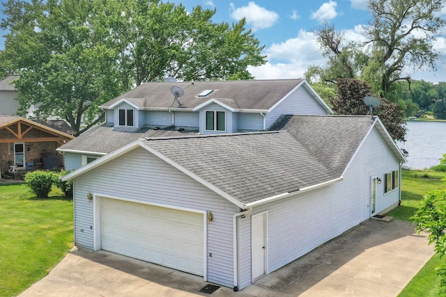 view of front of property with a garage, a shingled roof, a water view, concrete driveway, and a front yard