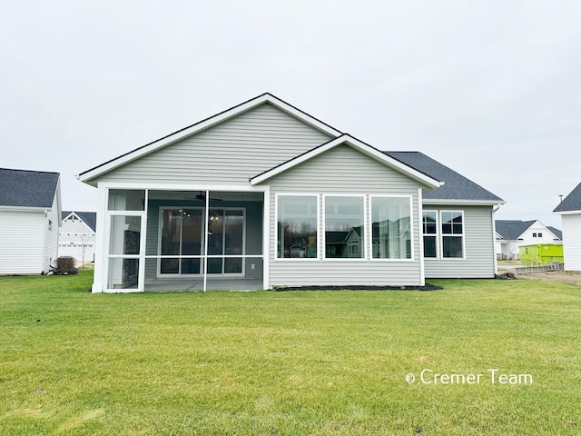 rear view of house with a lawn and a sunroom