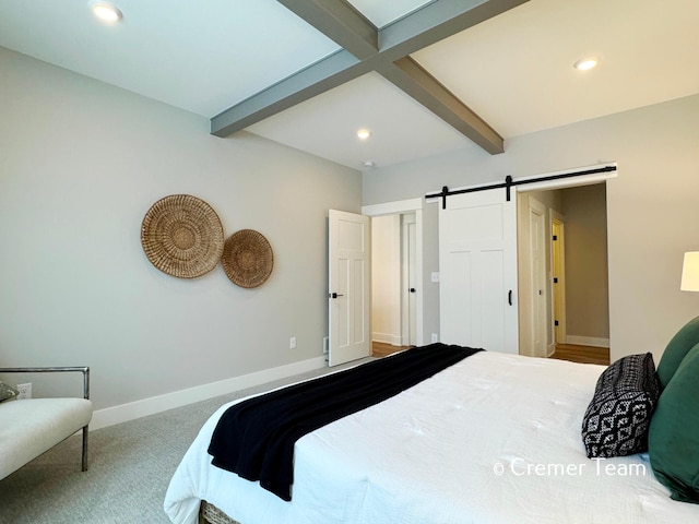 carpeted bedroom featuring beam ceiling and a barn door