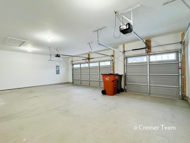 garage with a garage door opener and electric panel