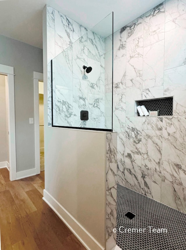 bathroom featuring a tile shower and hardwood / wood-style flooring