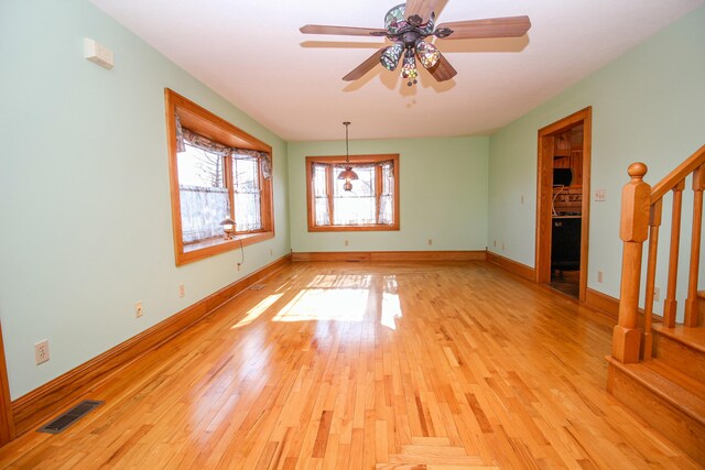 empty room with ceiling fan and light hardwood / wood-style flooring