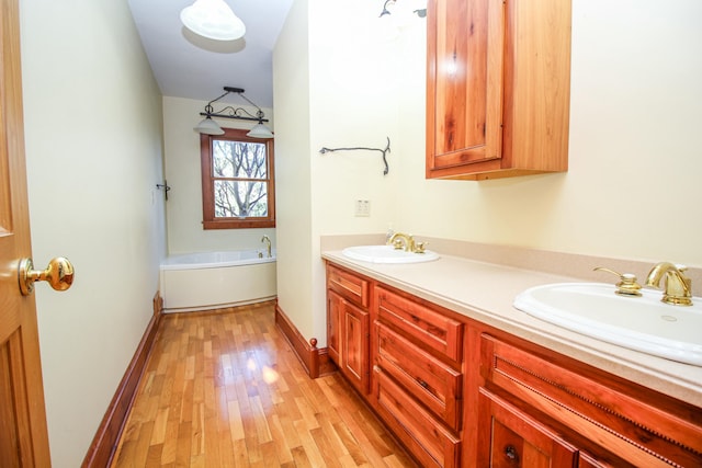 bathroom featuring hardwood / wood-style floors, vanity, and a bath