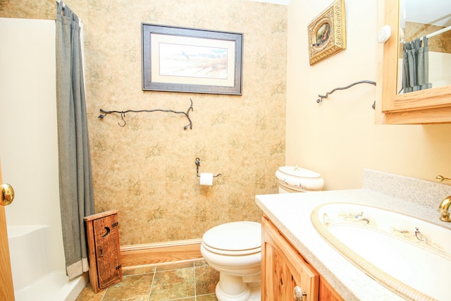 bathroom featuring curtained shower, vanity, and toilet