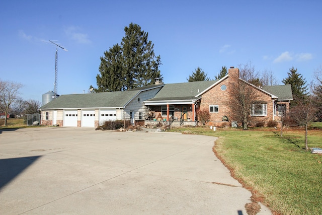 view of front of house with a front yard, a porch, and a garage