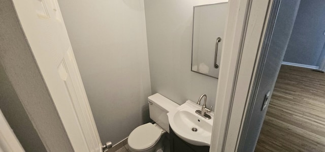 bathroom featuring toilet, vanity, and hardwood / wood-style flooring