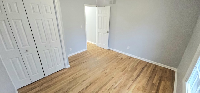 unfurnished bedroom featuring light hardwood / wood-style flooring and a closet