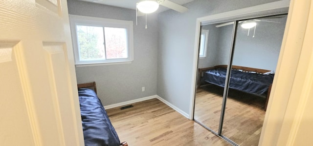 bedroom featuring ceiling fan, wood-type flooring, and a closet