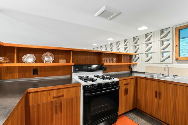 kitchen featuring white gas range and sink