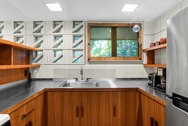 kitchen featuring stainless steel fridge and sink