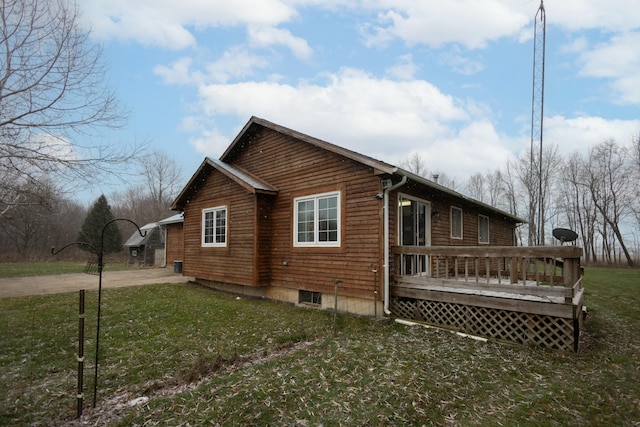 view of side of home featuring a lawn and a wooden deck