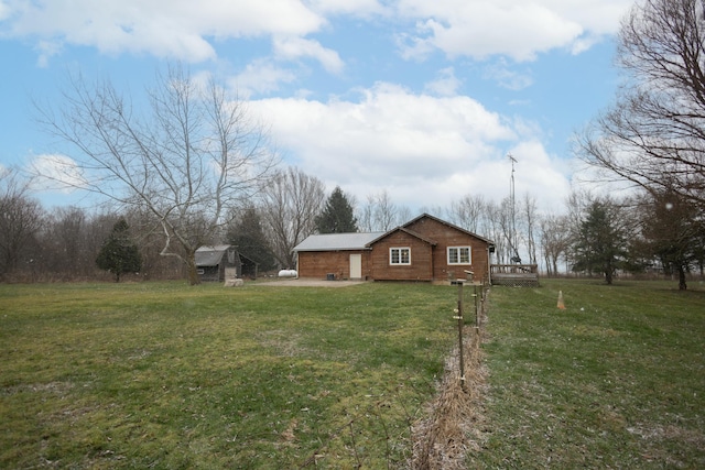 view of property exterior with a lawn, an outdoor structure, and a wooden deck