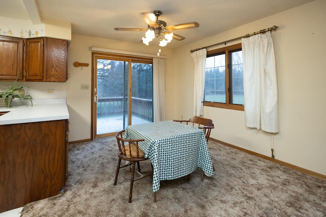 carpeted dining area with ceiling fan