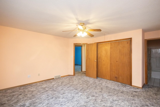 unfurnished bedroom featuring carpet floors, a closet, and ceiling fan