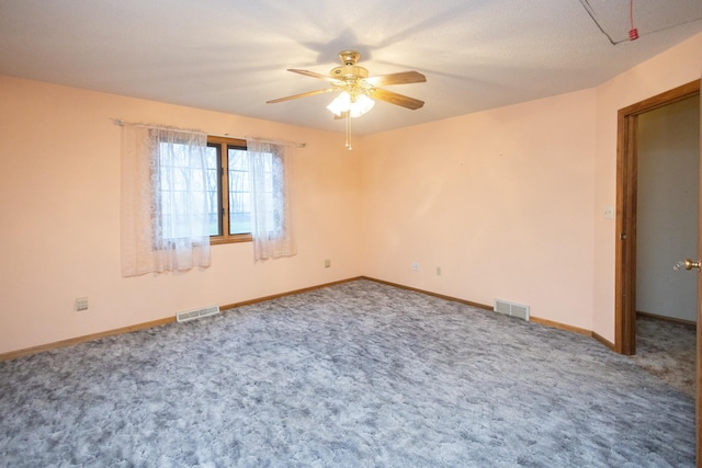 spare room with ceiling fan and carpet