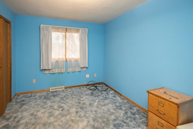 unfurnished bedroom featuring carpet floors and a textured ceiling