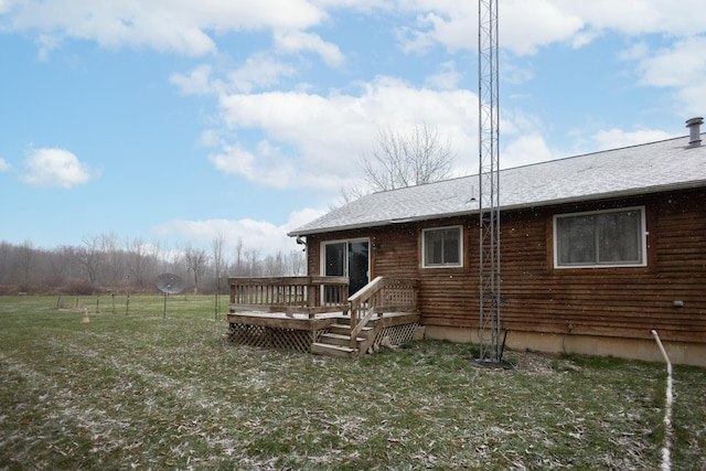 rear view of property featuring a wooden deck and a yard