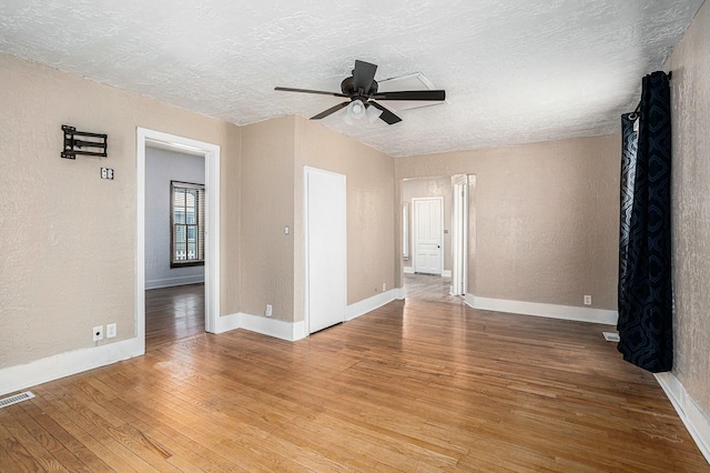 spare room featuring ceiling fan, wood-type flooring, and a textured ceiling