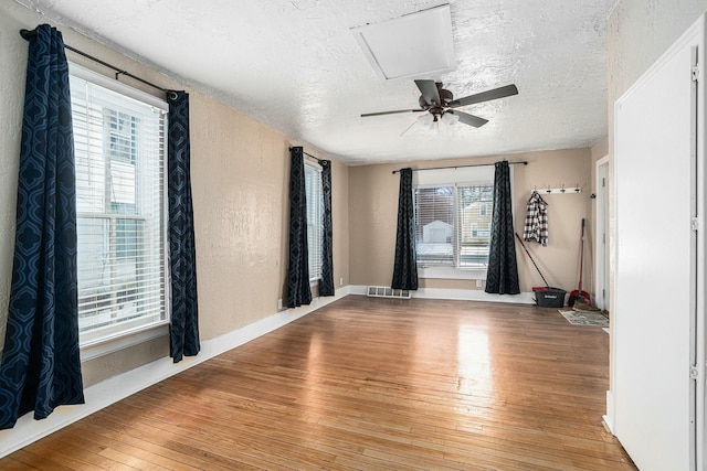 unfurnished room featuring ceiling fan, light hardwood / wood-style floors, and a textured ceiling