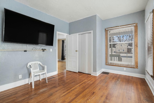 unfurnished bedroom featuring hardwood / wood-style floors and a closet