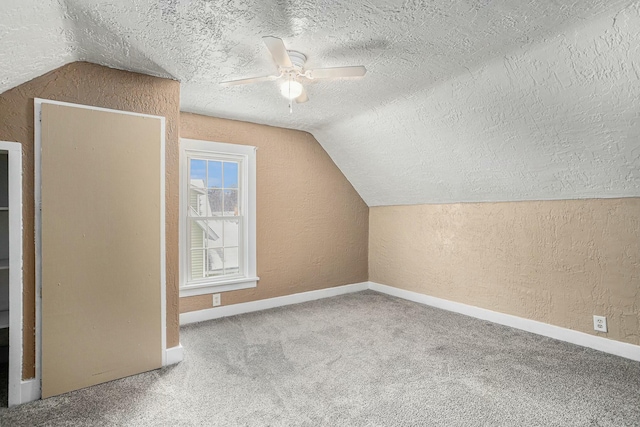 additional living space with a textured ceiling, ceiling fan, lofted ceiling, and carpet floors