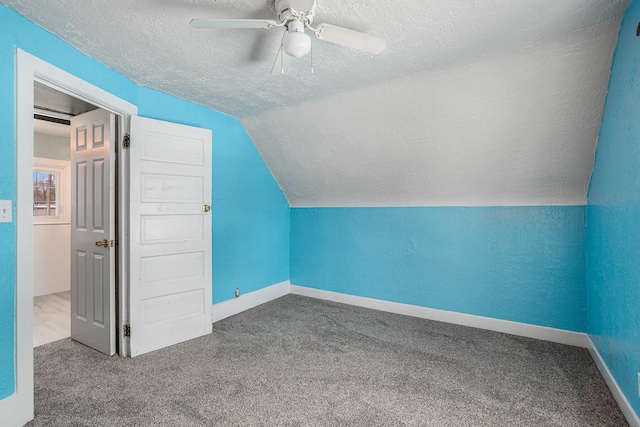 additional living space featuring carpet, ceiling fan, a textured ceiling, and vaulted ceiling