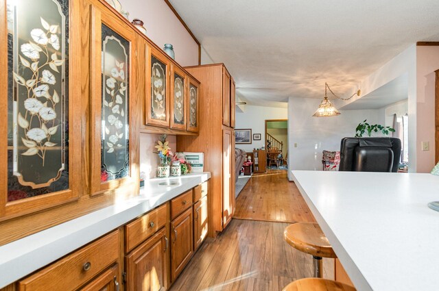 kitchen featuring a breakfast bar area, light hardwood / wood-style floors, and decorative light fixtures