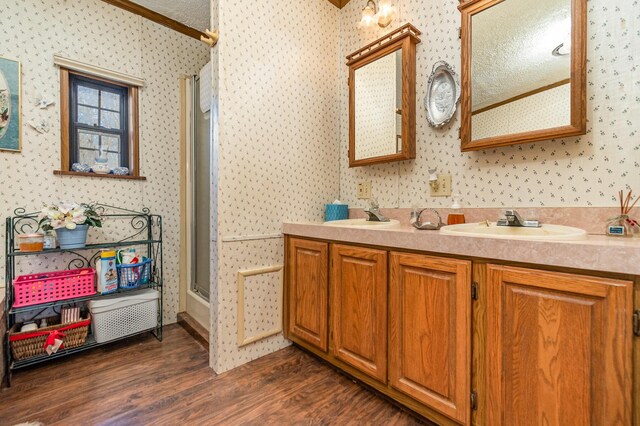 bathroom with vanity, wood-type flooring, ornamental molding, and walk in shower