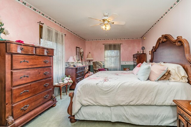 carpeted bedroom with multiple windows and ceiling fan