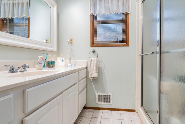 bathroom with tile patterned floors, vanity, and walk in shower