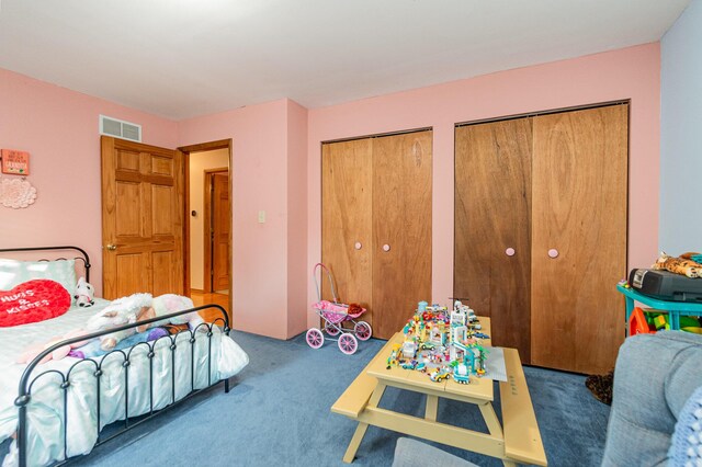 bedroom with carpet floors and multiple closets