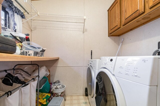 washroom with cabinets and washer and clothes dryer