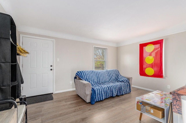 living room with ornamental molding and light wood-type flooring