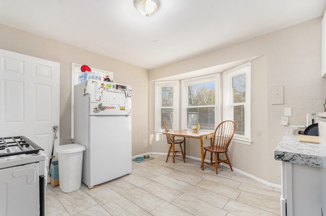 kitchen with white appliances and washer / clothes dryer