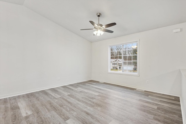 empty room with ceiling fan, lofted ceiling, and light hardwood / wood-style flooring