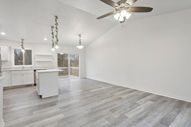 kitchen with white cabinets, ceiling fan, a center island, and a healthy amount of sunlight