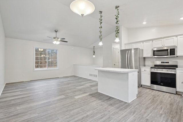 kitchen featuring white cabinetry, ceiling fan, vaulted ceiling, decorative light fixtures, and appliances with stainless steel finishes