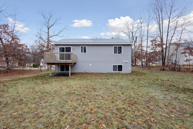 back of property with a yard and a wooden deck