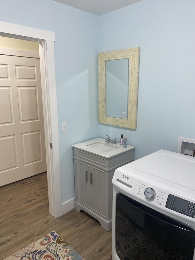 clothes washing area with dark hardwood / wood-style floors, sink, and washer / clothes dryer